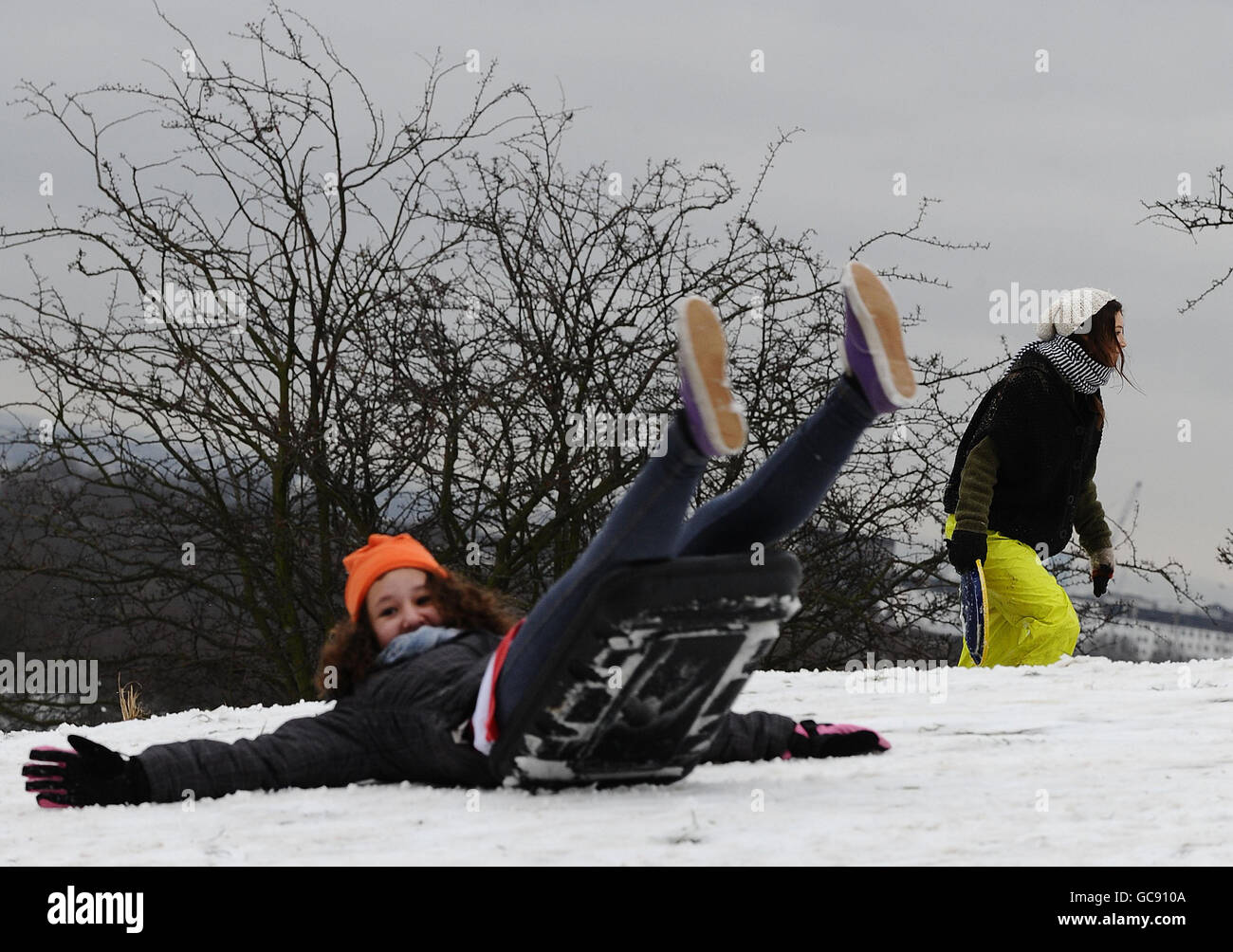 Persone che slittano sulla neve rimasta su Primrose Hill. Foto Stock