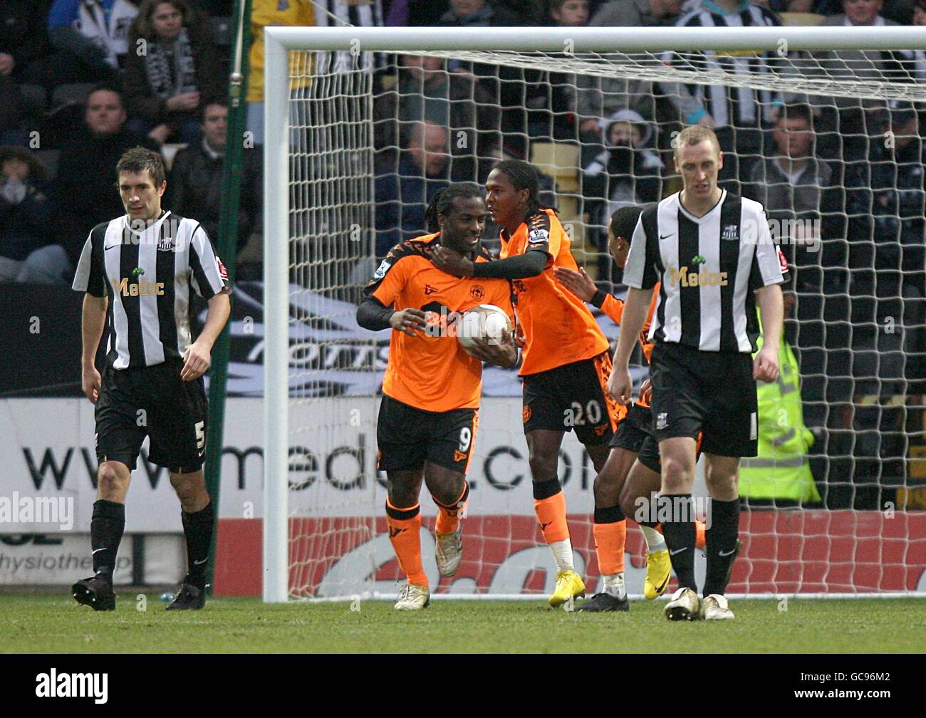 Jason Scotland di Wigan Athletic (seconda a sinistra) festeggia con il compagno di squadra Hugo Rodallega (seconda a destra) dopo aver segnato il loro primo goal. Graeme Lee (a sinistra) e Jamie Clapham (a destra) della contea di Notts camminano oltre abbattuto Foto Stock