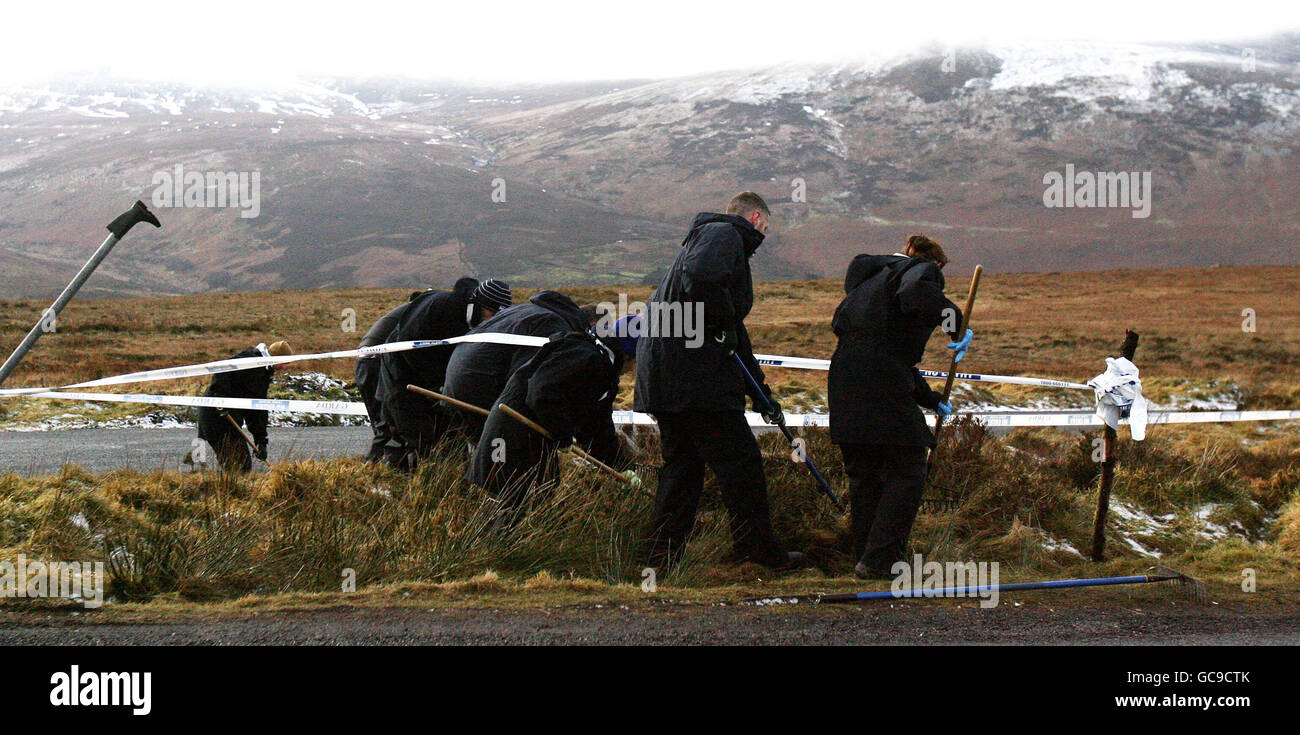 Gardai cerca la scena dove resti umani si trovano sulla strada militare nelle montagne di Dublino. Foto Stock