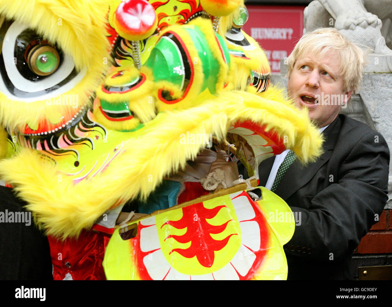 Il sindaco di Londra Boris Johnson tiene un costume da drago cinese presso una fotocellula nel quartiere cinese di Chinatown a Londra per promuovere le celebrazioni del Capodanno cinese della capitale, che segnano l'inizio dell'anno della Tigre domenica 21 febbraio. Foto Stock