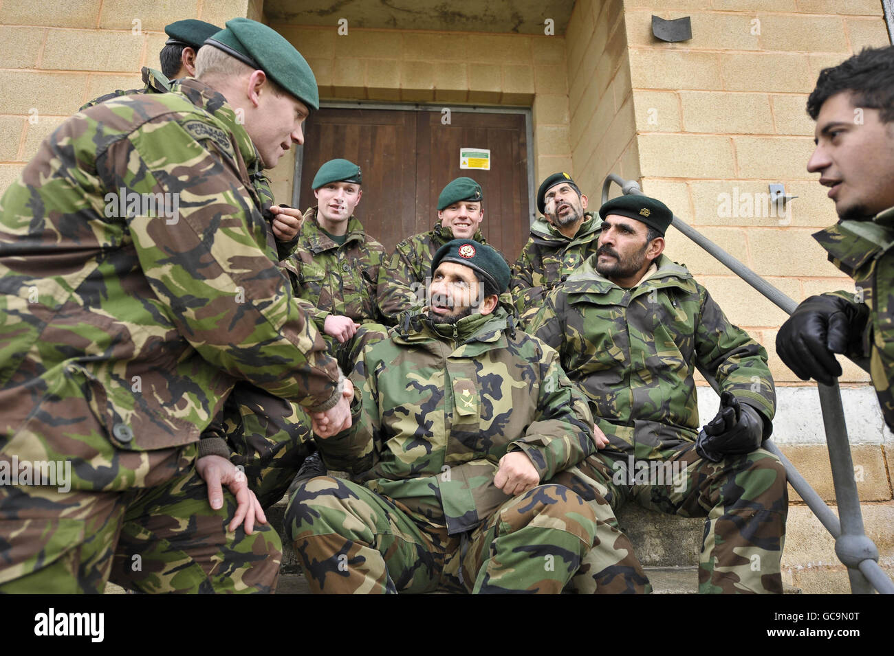 Royal Marine Commandos (nomi non dati) dal 40 Commando, con sede a Taunton, chiacchiera e rilassati con i soldati dell'esercito nazionale afgano (ANA) mentre si esercitano da vicino insieme su Salisbury Plain duringa esercizio di formazione pre-spiegamento per la quarta Brigata meccanizzata mentre si preparano per l'Afghanistan. L'uso di soldati ANA al servizio durante gli esercizi di pre-spiegamento è vantaggioso per le forze britanniche per iniettare realismo, aiutare a colmare le lacune culturali e migliorare l'esperienza che avranno a lavorare con l'ANA durante il combattimento. Foto Stock