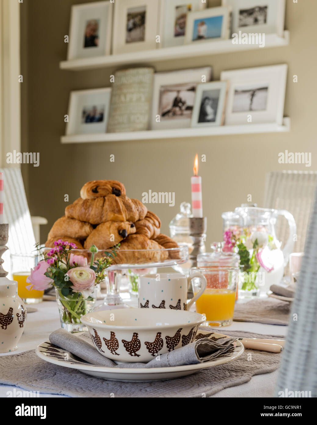 Pila di pain au chocolate sulla tabella prevista per la prima colazione. Floating ripiani sono nella parete di fondo la visualizzazione di famiglia Foto Stock