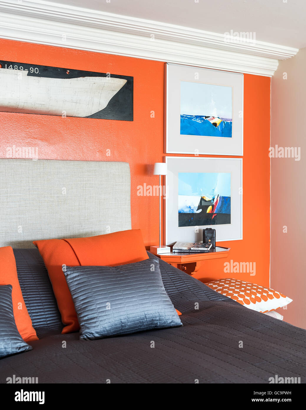 Illustrazione su arancio brillante parete sopra il letto in appartamento Londra Foto Stock