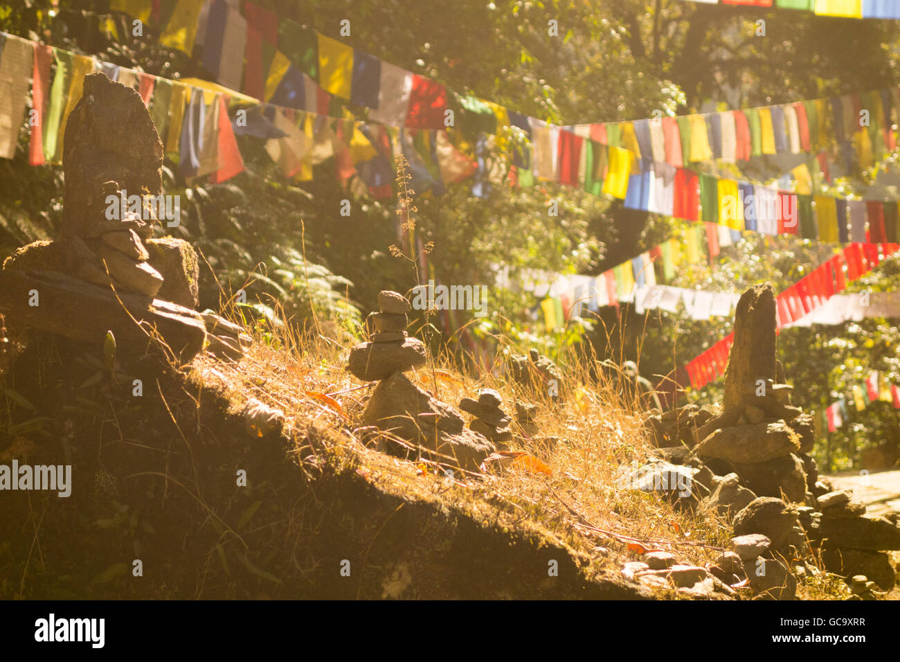 La preghiera buddista di bandiere e di religiosi impilati pietre disposte in corrispondenza di Khecheopalri Lake, ortografia, Sikkim, India Foto Stock