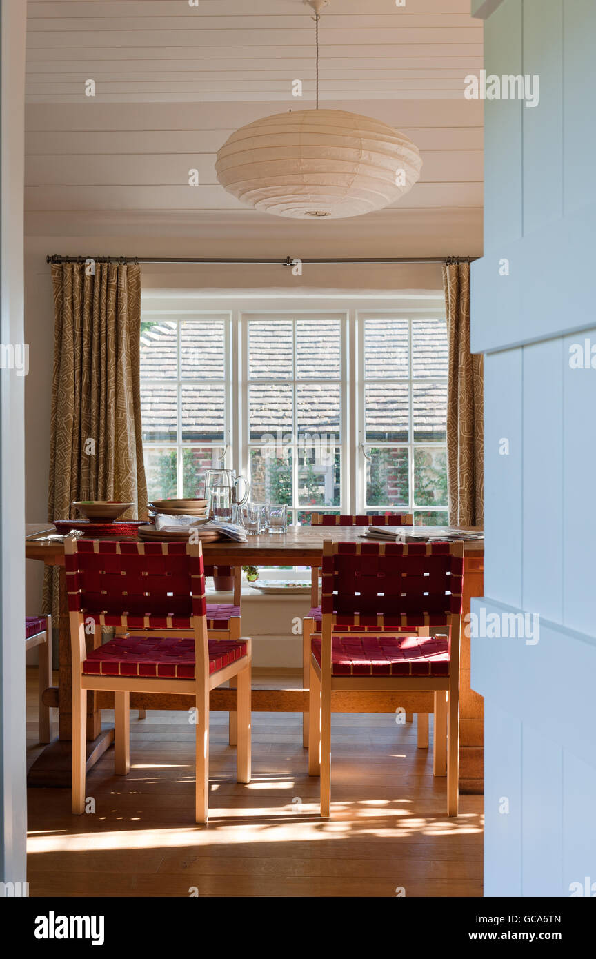 Vista attraverso porta in sala da pranzo con Alvar Aalto sedie e una carta Akari luce pendente da Isamu Noguchi da Conran Shop Foto Stock
