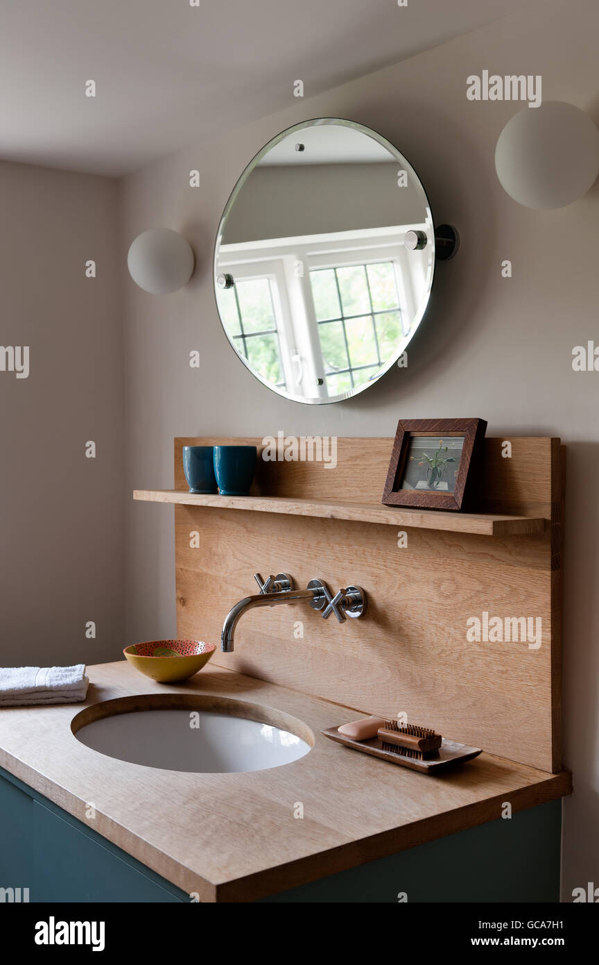 Oak vanity in bagno con specchio circolare Foto Stock