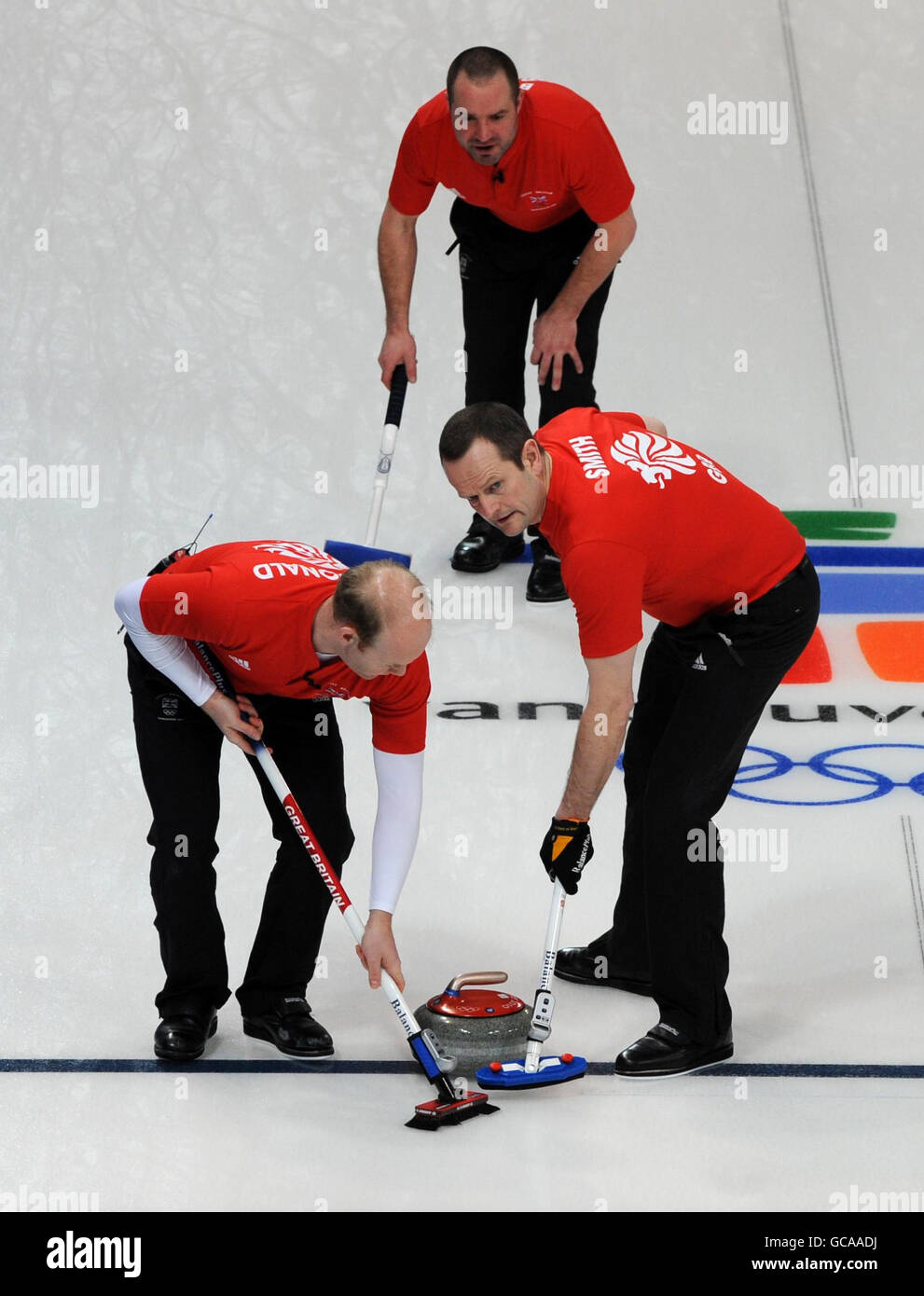 Ewan MacDonald della Gran Bretagna (a sinistra), Euan Byers (in alto) e Pete Smith in azione durante il Mens Curling contro la Svezia durante le Olimpiadi invernali del 2010 al Vancouver Olympic Center, Vancouver, Canada. Foto Stock
