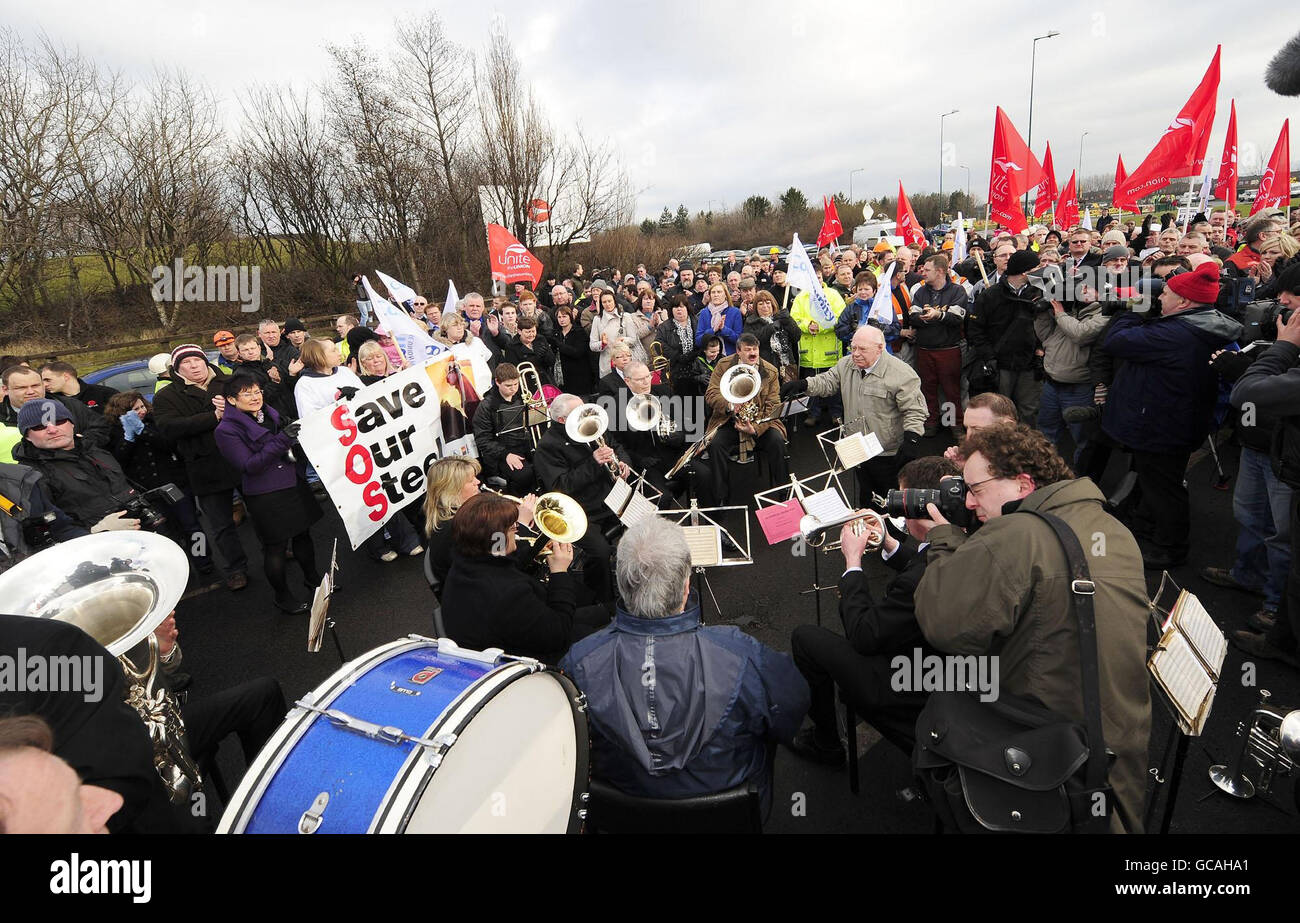 Una band si unisce oggi alle persone raccolte fuori dalle acciaierie Corus di Redcar, dove i lavoratori e le loro famiglie protestano per la motballatura dello stabilimento di Teeside con la perdita di 1,600 posti di lavoro. Foto Stock