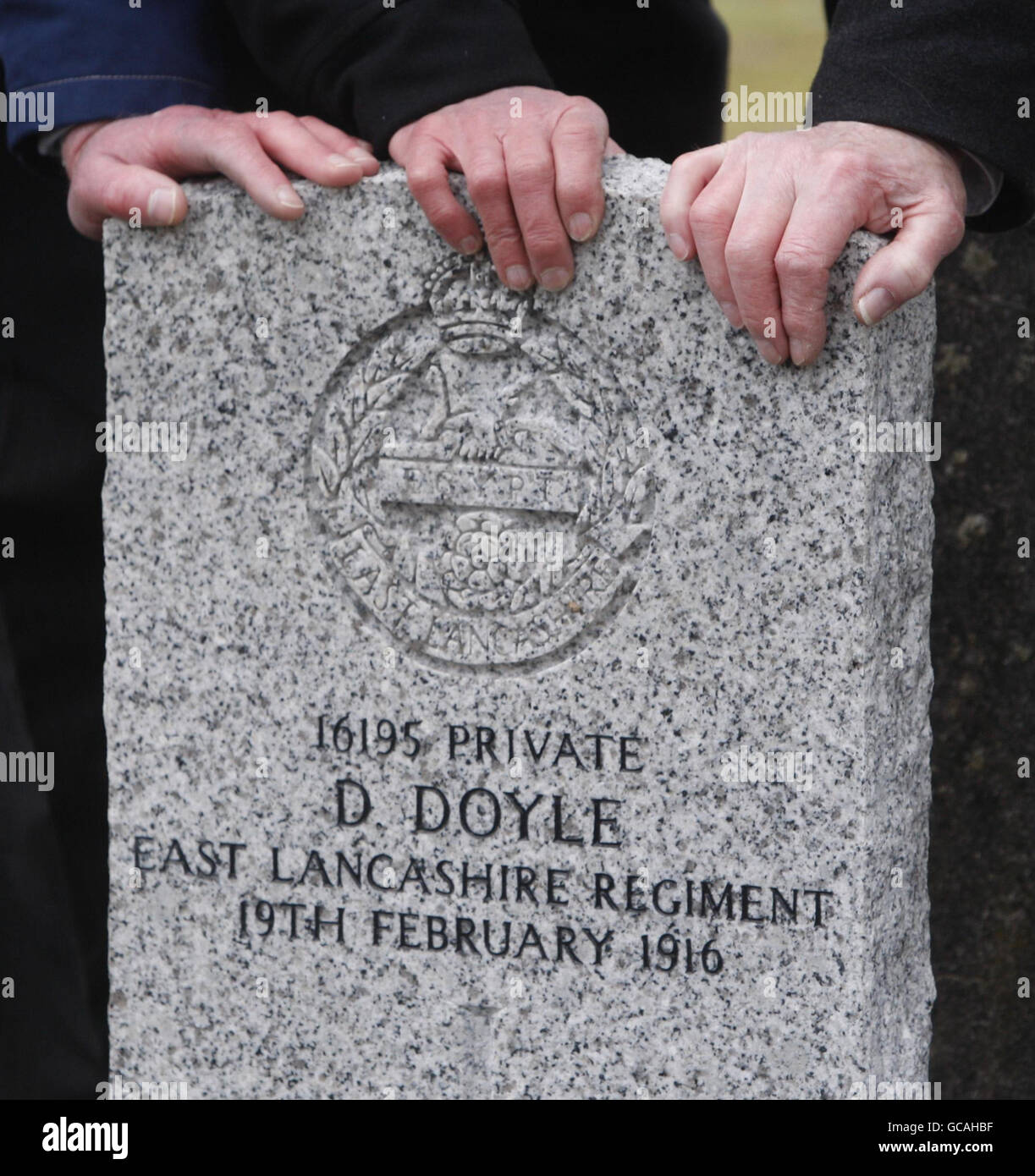 Parenti mani sulla tomba di Dennis Doyle al Cimitero di Cambusnethan, nel Lanarkshire del Nord, 94 anni al giorno in cui fu ucciso nella prima guerra mondiale. La Commonwealth War Graves Commission ha recentemente eretto una lapide per il soldato che servì nel Reggimento del Lancashire Orientale dopo che fu scoperto il suo ultimo luogo di riposo. Foto Stock