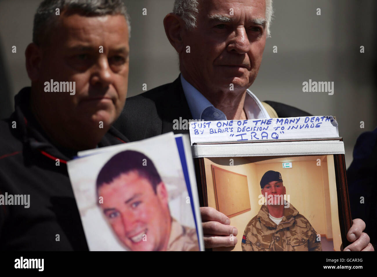 Un membro della famiglia in possesso di una fotografia di Stephen Robert Wright (destra), al di fuori della Queen Elizabeth II Conference Centre di Londra, dopo la pubblicazione della Chilcot inchiesta sulla guerra in Iraq. Foto Stock