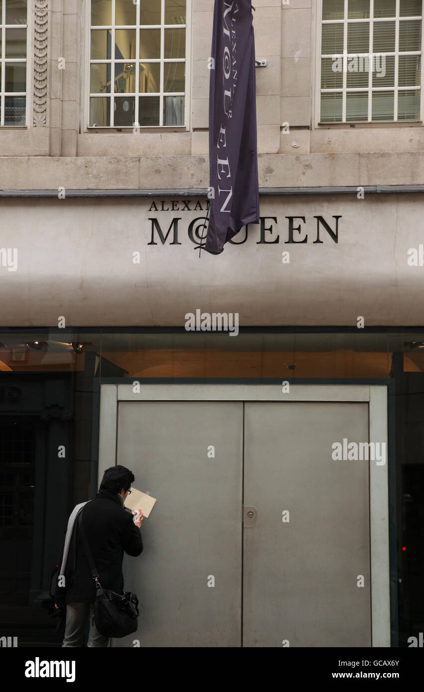 Una carta di simpatia e una bandiera a metà albero fuori dal negozio Alexander McQueen su Old Bond Street nel centro di Londra. Foto Stock