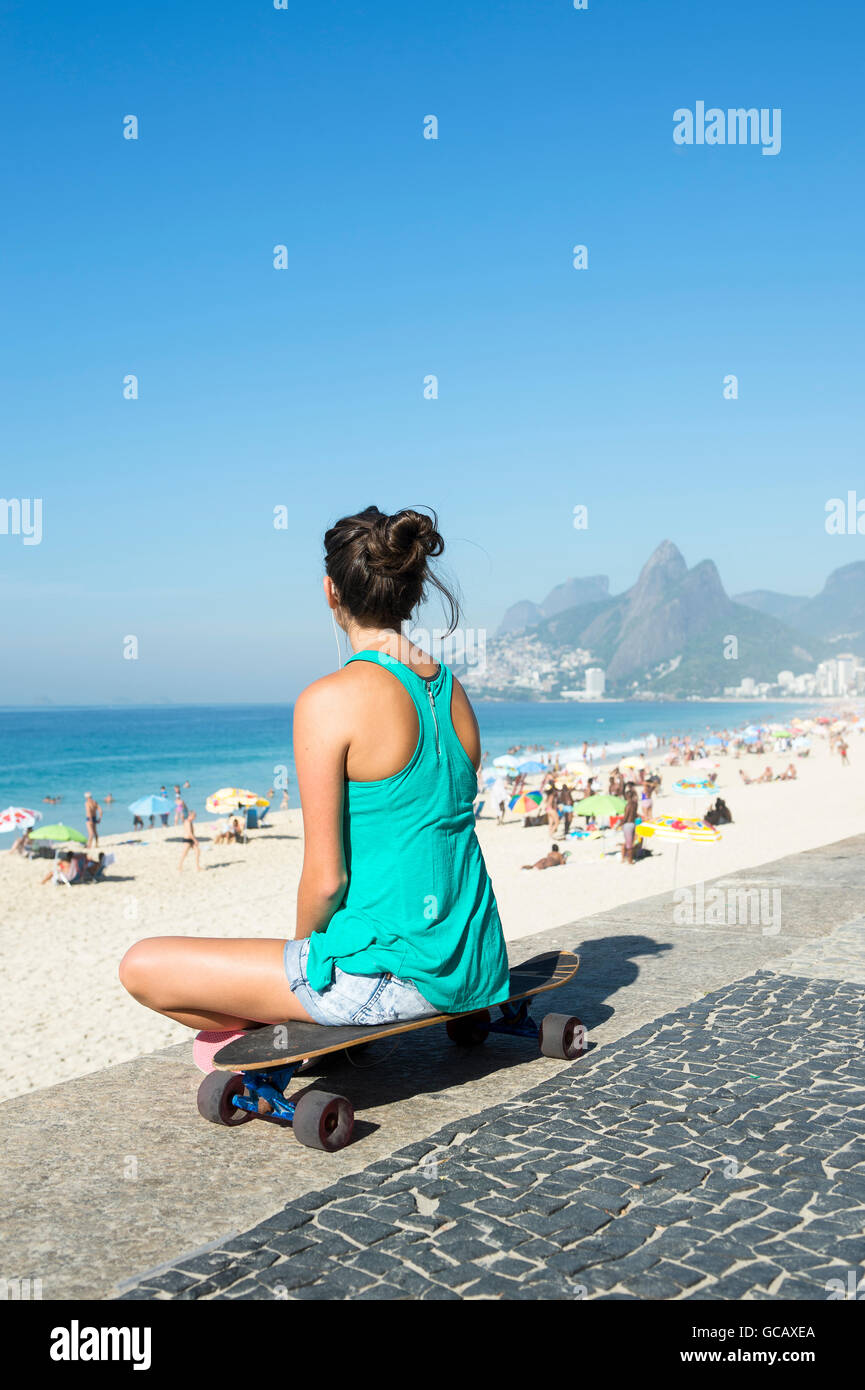 Giovani carioca donna brasiliana seduta sul suo skateboard affacciato sulla  spiaggia di Ipanema a Arpoador a Rio de Janeiro in Brasile Foto stock -  Alamy