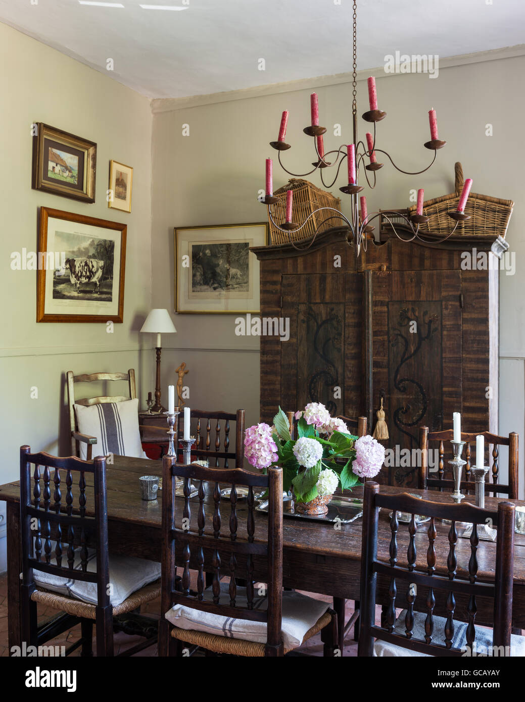 Xviii secolo tavolo in legno di quercia e Yorkshire sedie in sala da pranzo con pavimento in terracotta dipinta Armadio austriaco e il soffitto Foto Stock