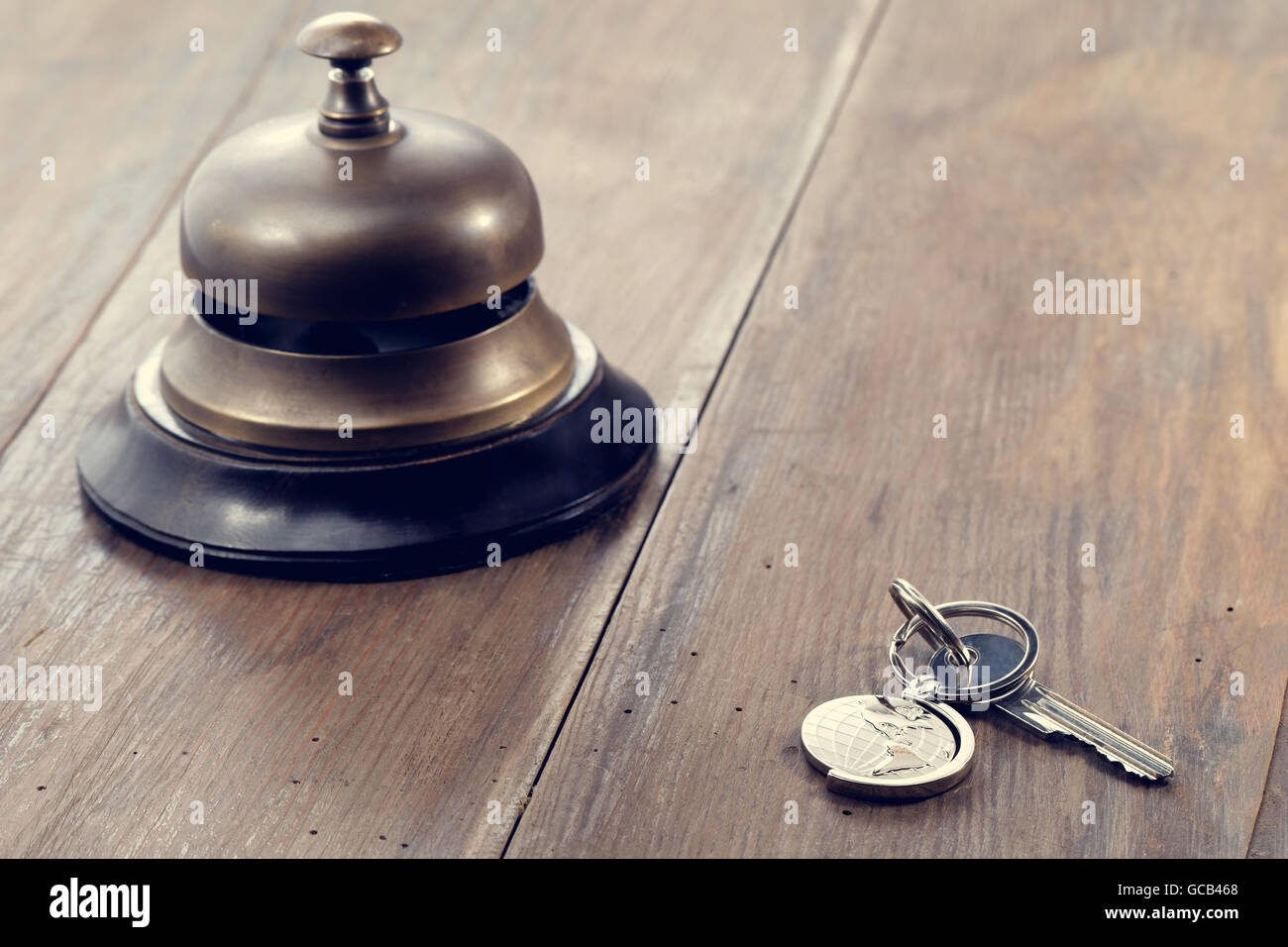 Campanellino e hotel key su un banco della reception Foto Stock