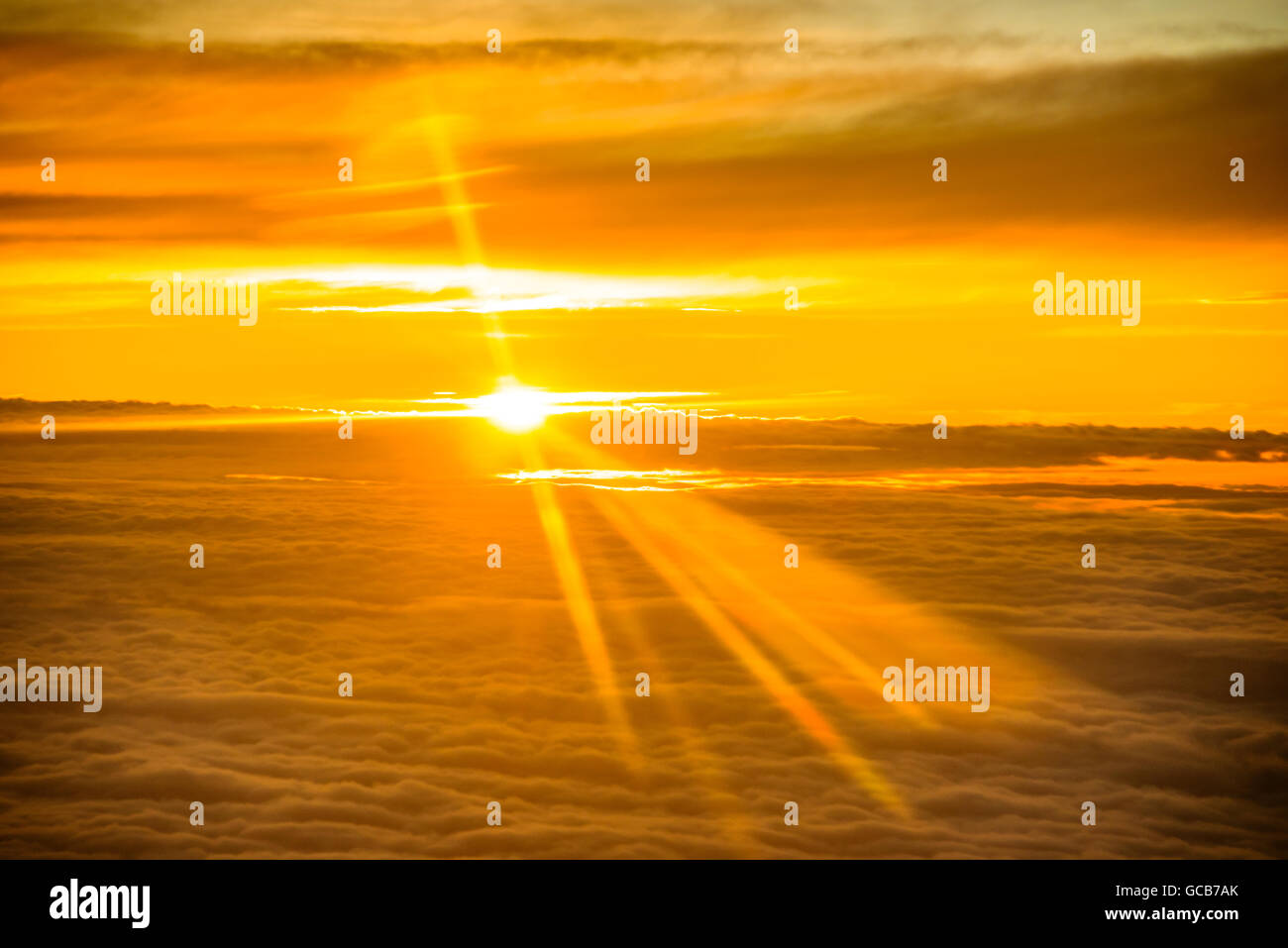 Il tramonto visto da aereo sopra le nuvole Foto Stock