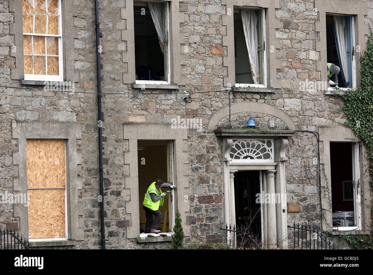 Gli uomini lavorano su un edificio danneggiato a seguito di un attacco di auto-bomba dissidente all'esterno, il tribunale di Newry a Co Down, poco dopo le 22:30 di lunedì. Foto Stock