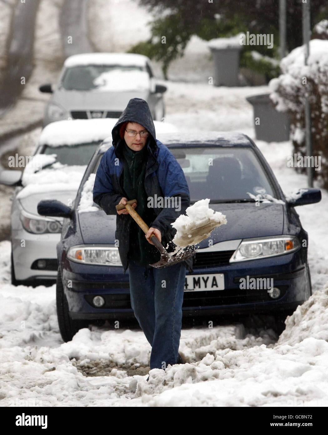 NOTARE IL PRODOTTO ALTERNATIVO. Un uomo tinge la neve a Newton Mearns dopo che la neve pesante cade attraverso la Scozia durante la notte. Foto Stock