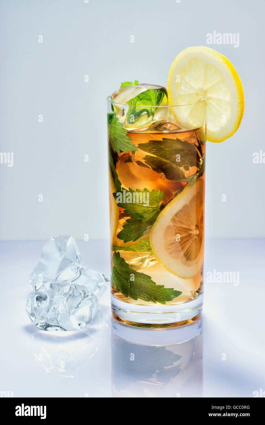 Bibita al limone con ghiaccio in un bicchiere sulla superficie bianca Foto Stock