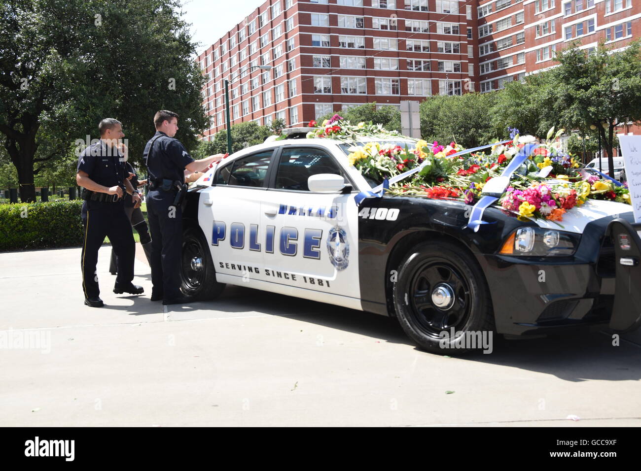 Dallas, Texas, Stati Uniti d'America. 8 Luglio, 2016. Dallas funzionari di polizia poco prima di mezzogiorno del 8 luglio 2016 decorare un auto della polizia al di fuori di Dallas questura con fiori donati dalla polizia e un locale Sam's Club store. Credito: Hum Immagini/Alamy Live News Foto Stock