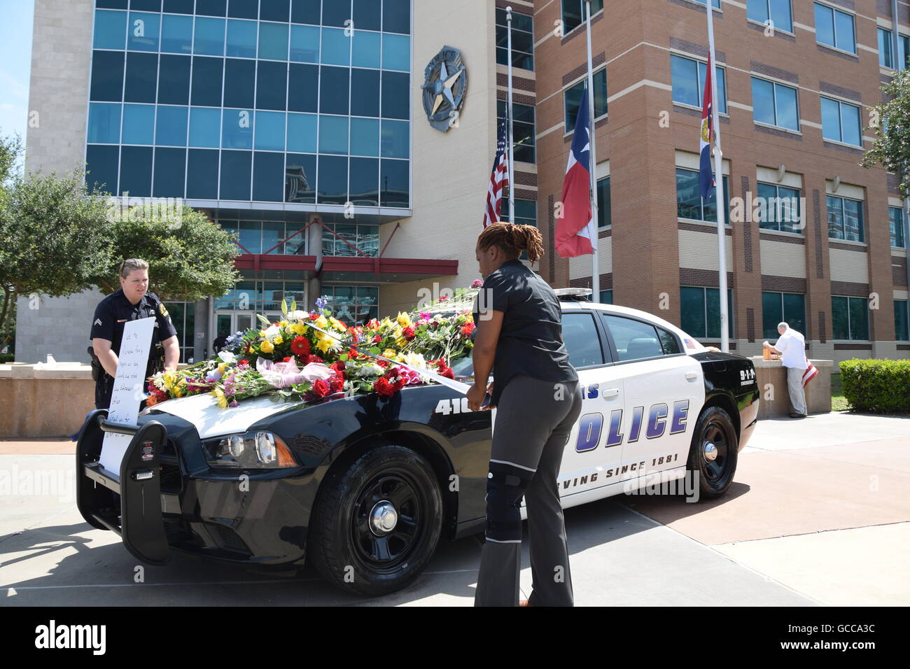 Dallas, Texas, Stati Uniti d'America. 8 Luglio, 2016. Dallas funzionari di polizia poco prima di mezzogiorno del 8 luglio 2016 decorare un auto della polizia al di fuori di Dallas questura con fiori donati dalla polizia e un locale Sam's Club store. Credito: Hum Immagini/Alamy Live News Foto Stock