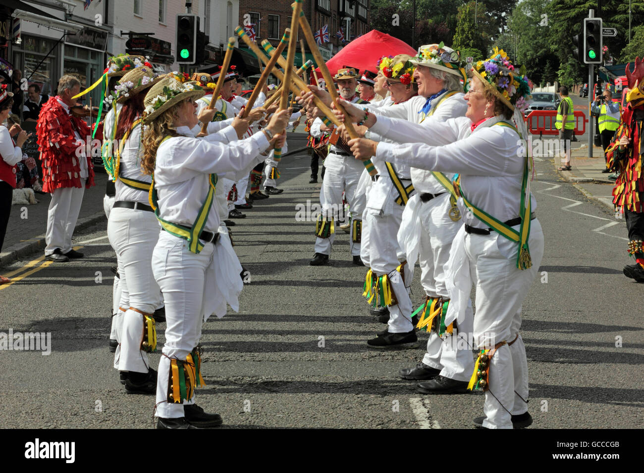 Ewell, Epsom Surrey, Inghilterra, Regno Unito. Il 9 luglio 2016. La Spring Grove Kingston Morris uomini effettuando al Ewell Village Fair, Surrey, sul tempo speso bene giorno di danza. Essi sono stati uniti da ballare i lati da Carshalton and Ewell St Mary Morris uomini e il dilagante Galli Dorking per rendere uno degli schermi più grandi di Morris uomini. Essi hanno iniziato a Green Man pub per trenta minuti di ballo prima di sfilare lungo la High Street per il lock up per una sfida da bere e poi su off per più ballare. Credito: Julia Gavin UK/Alamy Live News Foto Stock