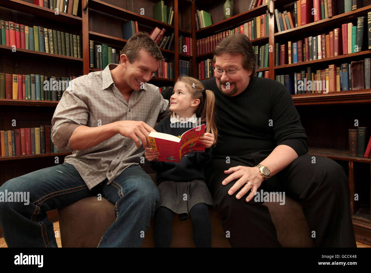 Giornata mondiale del libro a Wrestlemania la sfida della lettura : World Wrestling Entertainment (WWE) lottatori Ted DiBiase Junior, (sinistra), e suo padre "Million Dollar Man' Ted DiBiase con Betty McAdden, 7, un partecipante alla Giornata Mondiale del libro a WrestleMania la sfida della lettura, un concorso gestito in collaborazione con il National Literacy Trust, alla cannella Club nel centro di Londra. Foto Stock