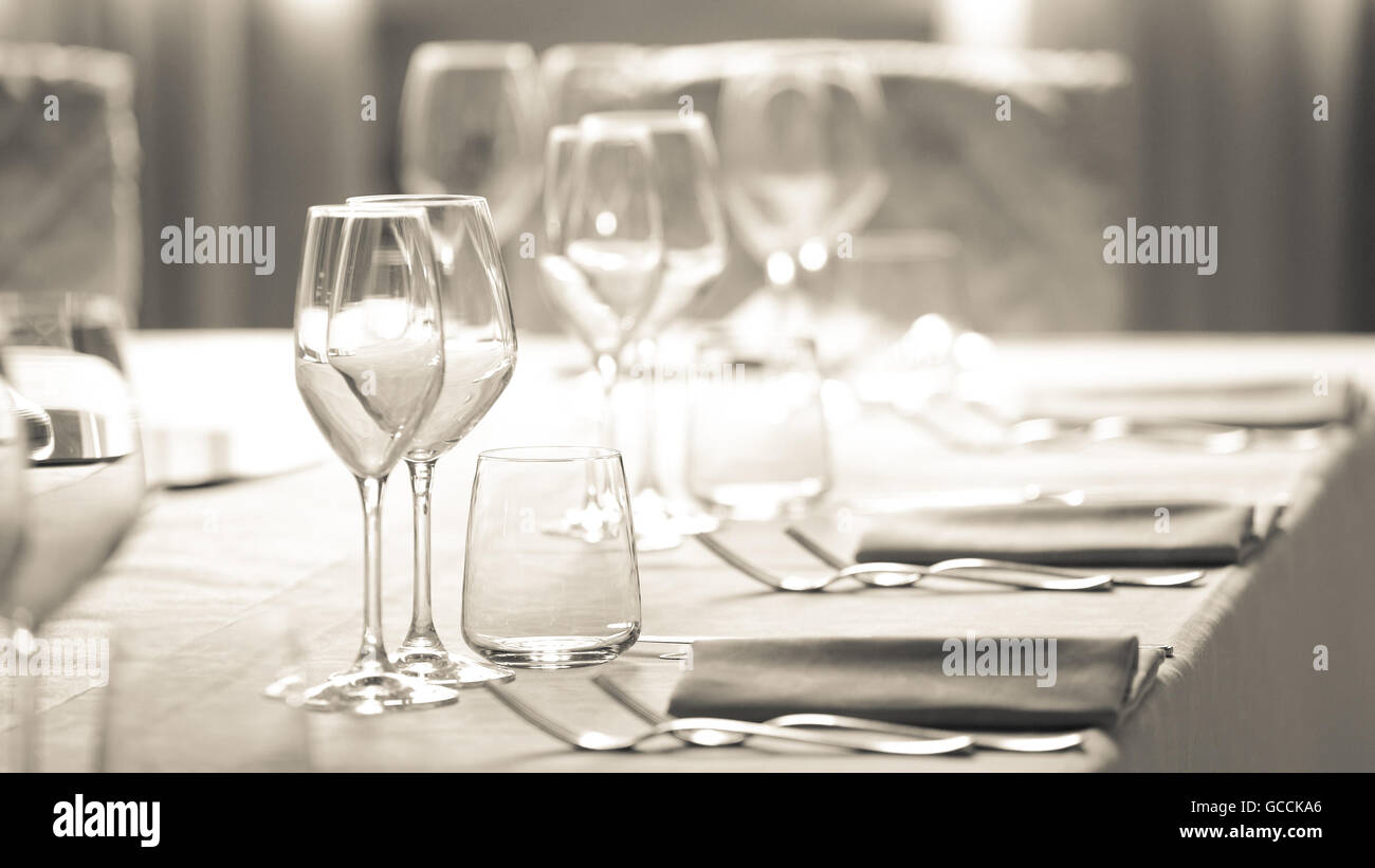 Tavolo con tovaglia bianca e bicchieri di cristallo. Foto Stock