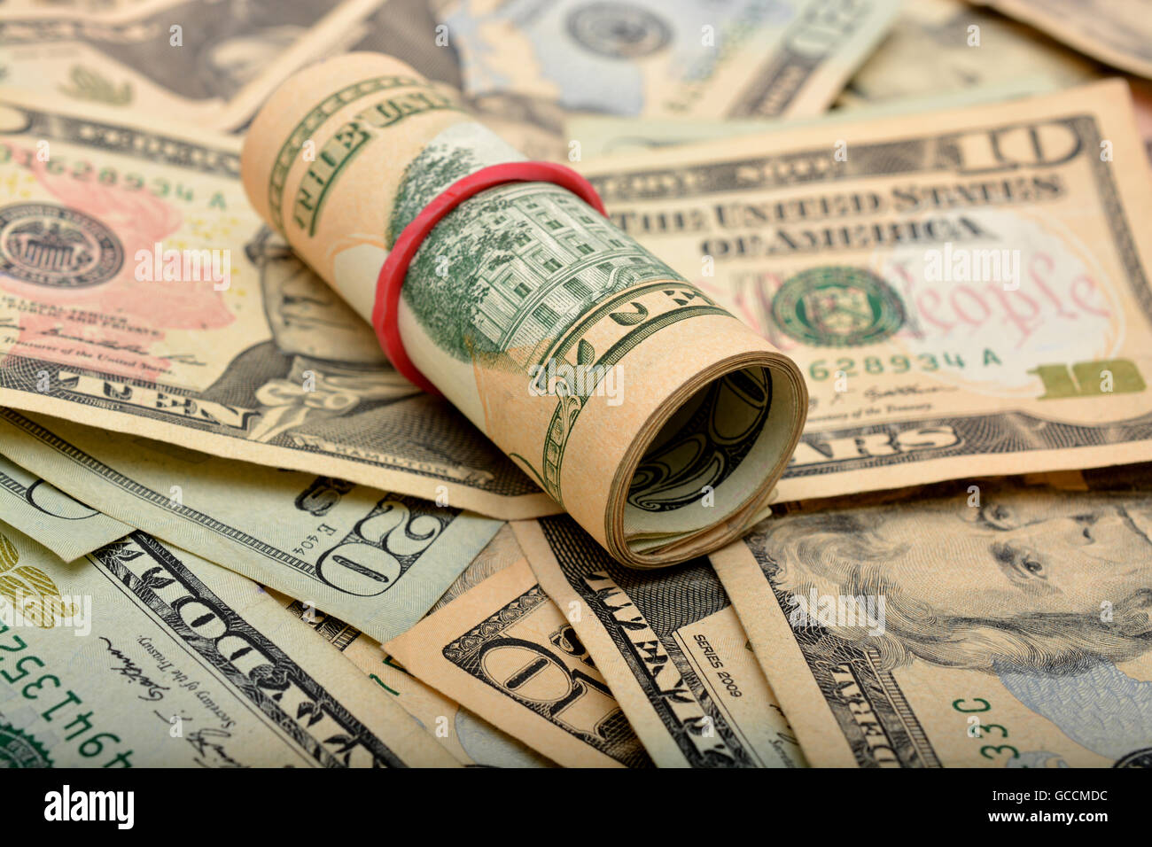 Piegare di dollari con il denaro dello sfondo. Foto Stock