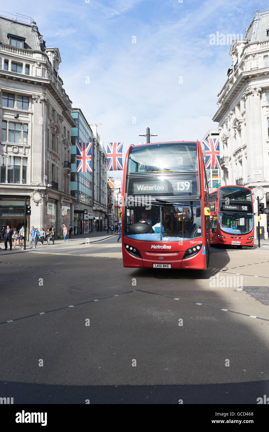London street scene e autobus rossi con union jack flag Foto Stock