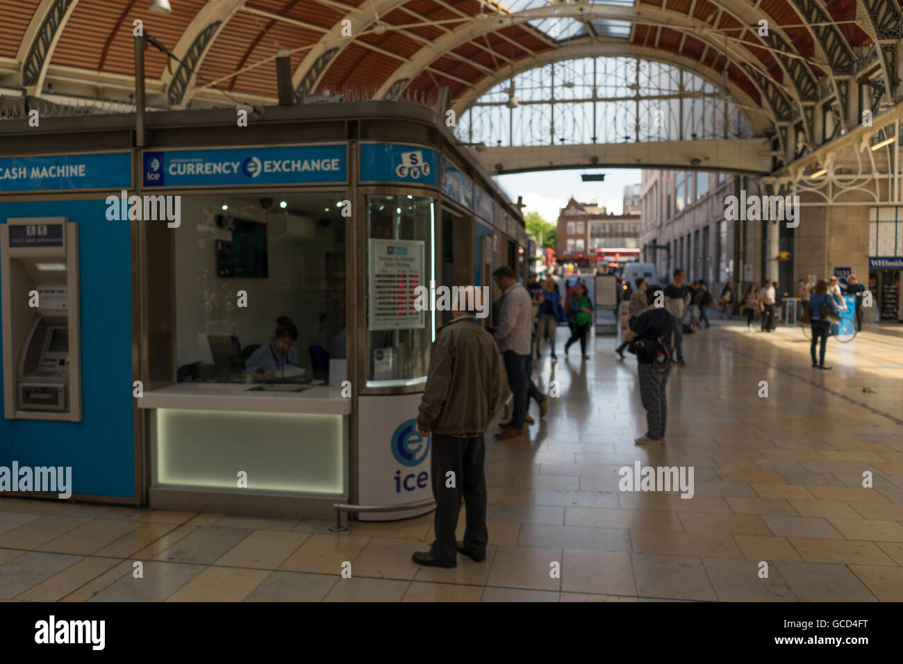 Uomo che guarda i tassi di cambio nella finestra di un ufficio di cambio in una stazione ferroviaria Foto Stock