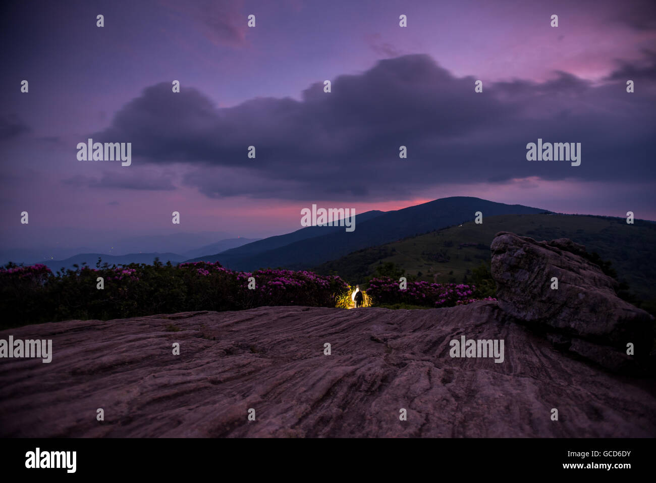 Gli escursionisti scendono Jane Calvo al crepuscolo civile con purpureo tramonto persistente di monte Foto Stock