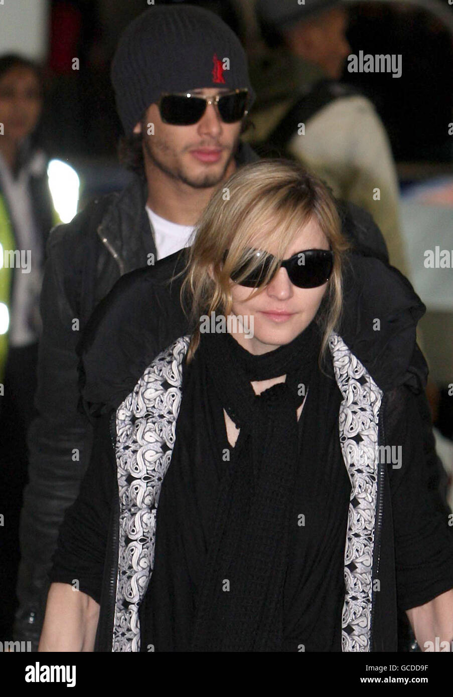 Madonna atterra all'aeroporto di Heathrow con Jesus Luz (parte posteriore) e i suoi figli David banda, Mercy James e Lourdes. Foto Stock
