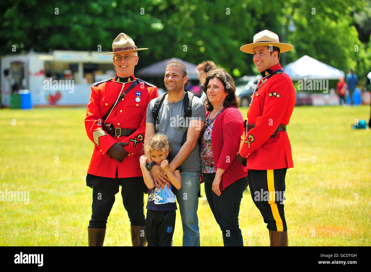 Una famiglia comportano per le foto con due Canadian Mounties a Canada Day festival a Londra, Ontario. Foto Stock