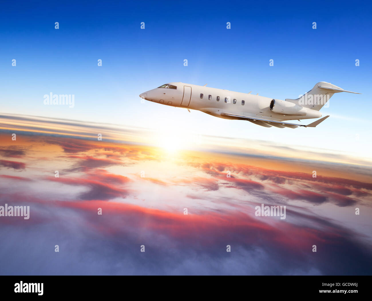 Jet Privato aereo volare sopra le nuvole in bel tramonto. Scattato dalla vista frontale Foto Stock