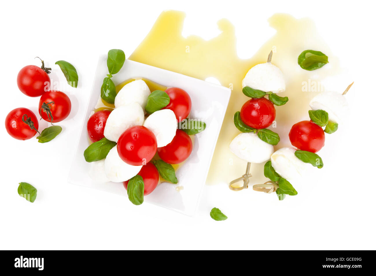 Freschi e deliziosi caprese sul tavolo bianco. Mozzarella, basilico fresco e pomodorini con olio extra vergine di oliva. Foto Stock