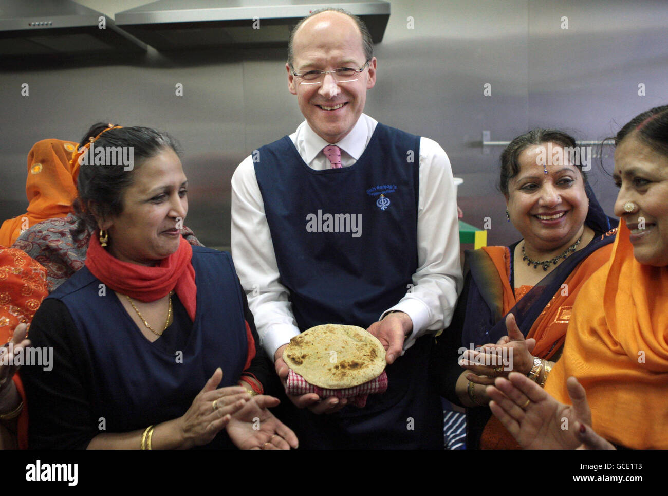 Il Segretario delle Finanze John Swinney ha lezioni su come preparare e cucinare chapati a Punjab'n de Rasoi, Edimburgo, mentre partecipa all'apertura ufficiale del nuovo Sikh cafe che è stato creato con l'aiuto dei finanziamenti governativi. Foto Stock