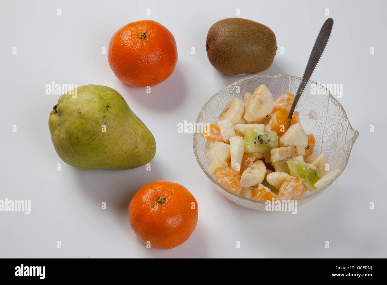 Frutto accanto a una ciotola di insalata di frutta Foto Stock
