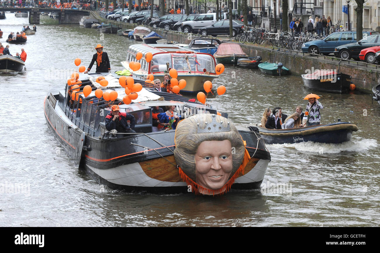 Una delle più grandi feste di strada del mondo si svolge oggi mentre l'Olanda celebra Queensday. I canali e le strade di Amsterdam sono pieni di decine di migliaia di persone che celebrano le festività pubbliche con i modelli della Regina Beatrice dei Paesi Bassi fissati alle barche che trasportano i festaioli lungo i chilometri di canali. Foto Stock