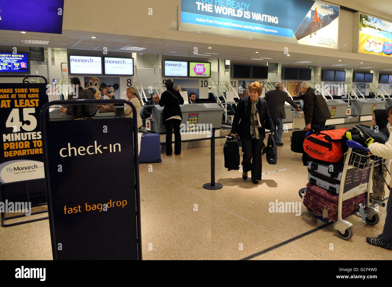I passeggeri effettuano il check-in per il volo Monarch Airways a Faro, Portogallo, dall'aeroporto di Birmingham, dopo che i cieli del Regno Unito si riaprirono in mezzo a una fila continua sulle restrizioni di volo causate dalla nube di cenere vulcanica. Foto Stock