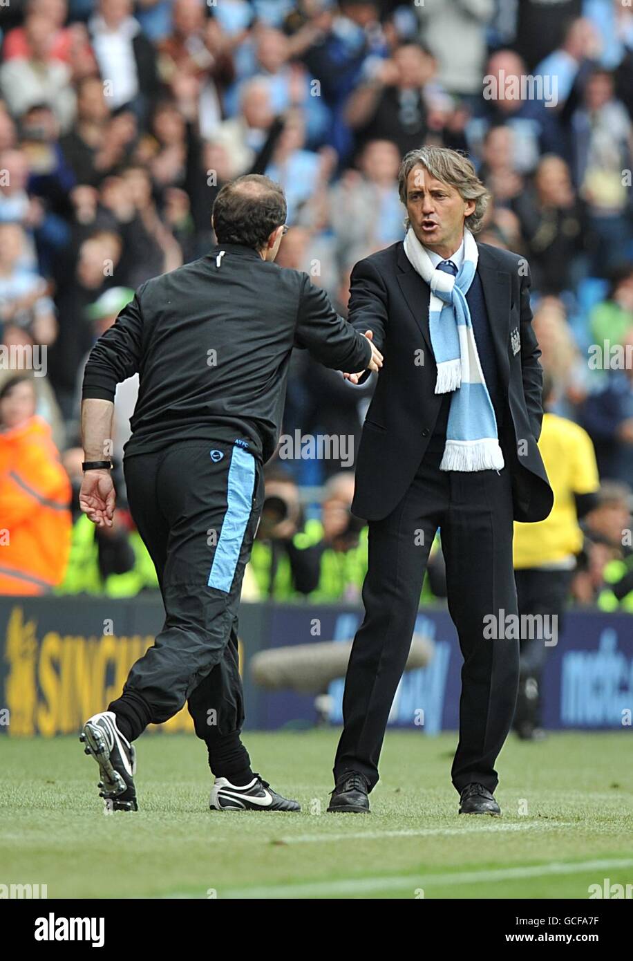 Il manager Aston Villa Martin o'Neill (a sinistra) e il manager della città di Manchester Roberto Mancini (a destra) scuotono le mani dopo il fischio finale sulla linea di contatto. Foto Stock