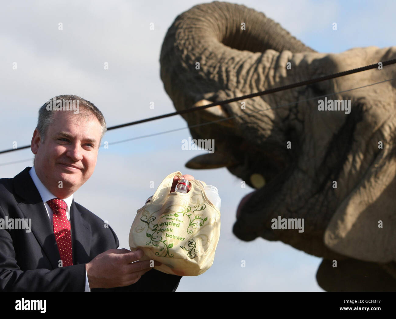 Il Segretario per l'ambiente Richard Lochhead con l'elefante Estrella e alcune bottiglie per il riciclaggio, come egli aiuta a lanciare la campagna di riciclaggio, Zero Waste Project, al Blair Drummond Safari Park. Foto Stock