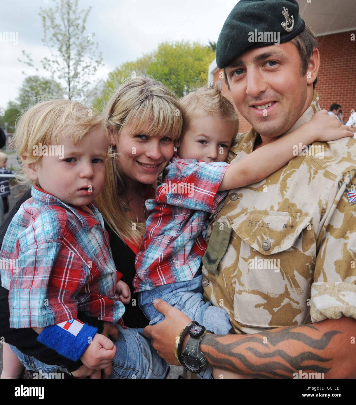 Il caporale di lancia Tony Pearce di Un'azienda 4° Battaglione i Rifles è accolto da sua moglie Charli (corretto) e dai figli Tige (corretto), quattro e Harley, uno, al suo arrivo alla sua base a Bulford, Wiltshire, dopo un tour di sei mesi in Afghanistan. Foto Stock
