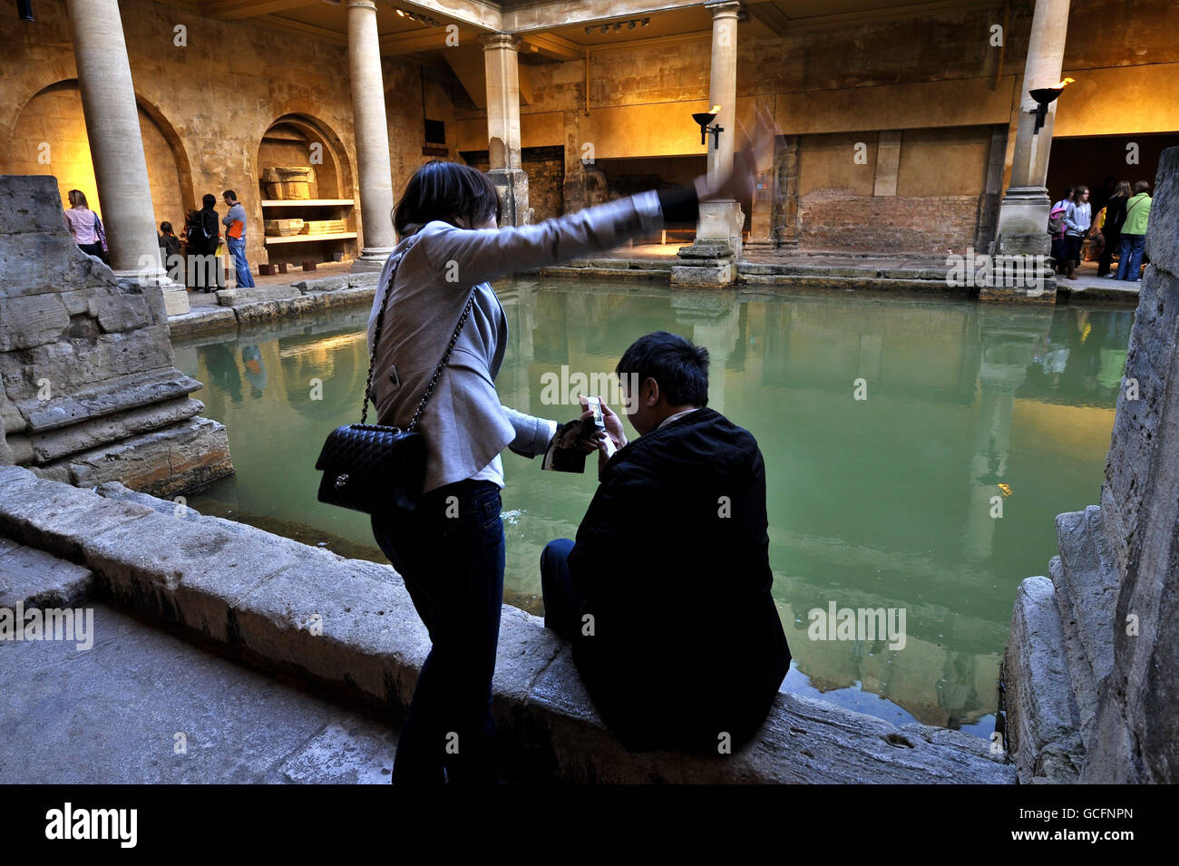 Una coppia scatta foto su un telefono cellulare all'interno del Grande bagno mentre i turisti possono sfruttare al massimo gli orari di apertura prolungati presso le Terme Romane di Bath, dove ha aperto fino a tarda notte come parte del 'Musei alla Notte 2010'. Foto Stock