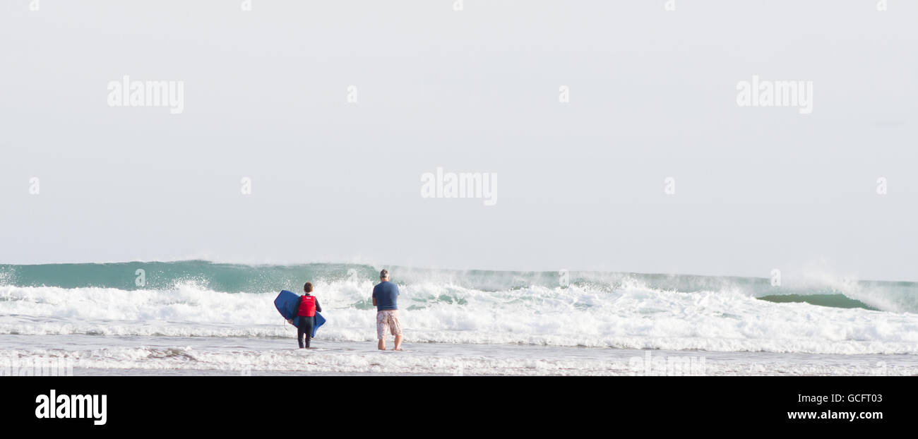 Padre e figlio in attesa di un onda adatto per il surf Foto Stock