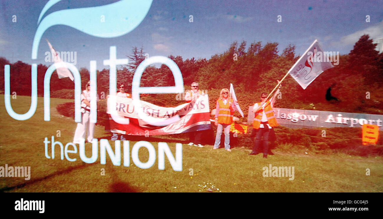 L'equipaggio di cabina della British Airways e i membri Unite, fotografati attraverso una bandiera dell'Unione Unite, imitano una linea di picket all'aeroporto di Glasgow. L'equipaggio di cabina ha lanciato la prima di un'ondata di scioperi che minaccia di interrompere i voli per settimane. Foto Stock