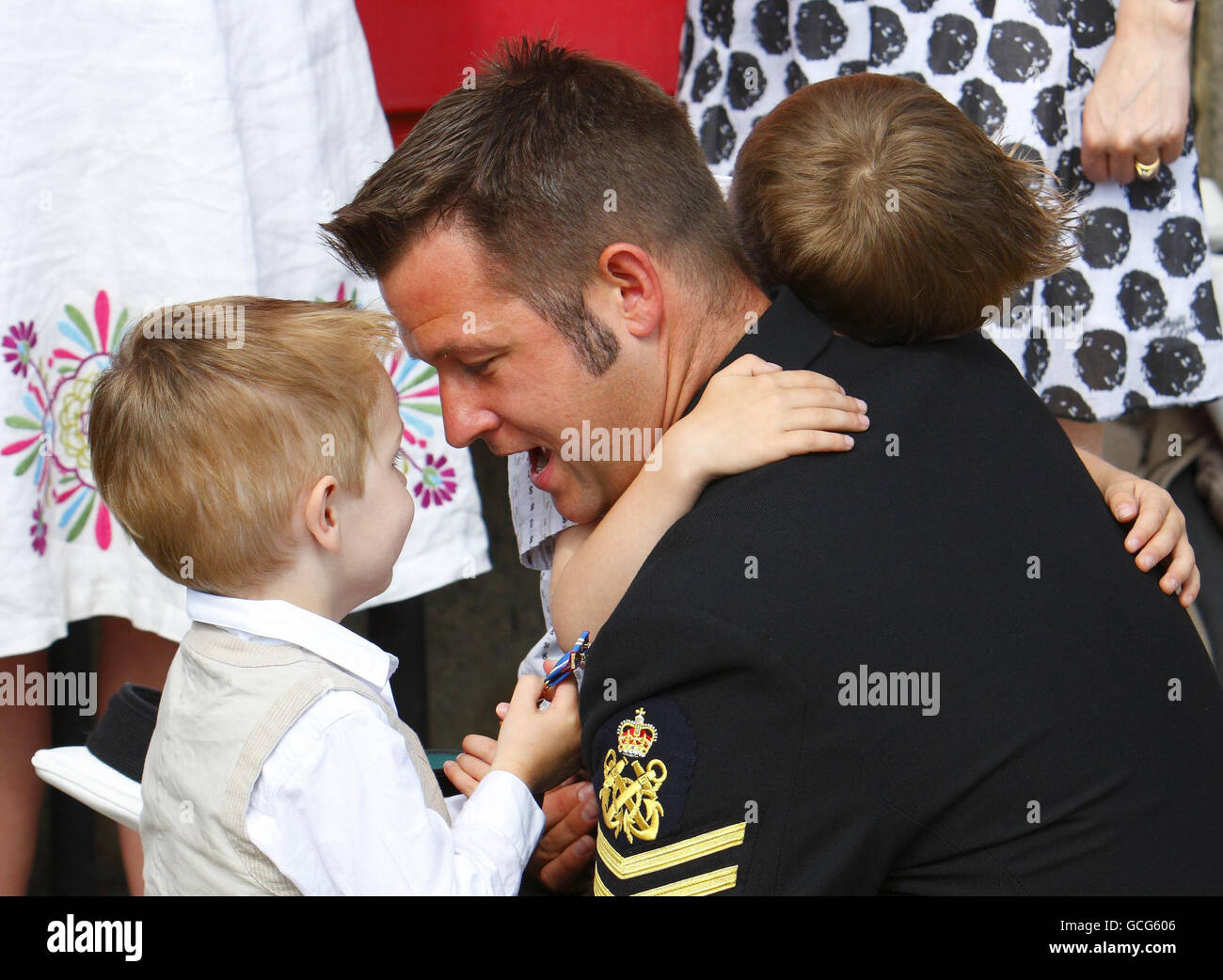 Il piccolo ufficiale Phil Nelson è accolto a casa dai suoi figli Dylan, 5, e Alfie, 2, (a sinistra) dopo che la sua nave HMS Atherstone tornò alla base navale di Portsmouth dopo aver prestato servizio nel Golfo Arabico contribuendo a mantenere la sicurezza nella zona e a svolgere l'addestramento alla guerra delle mine. Foto Stock