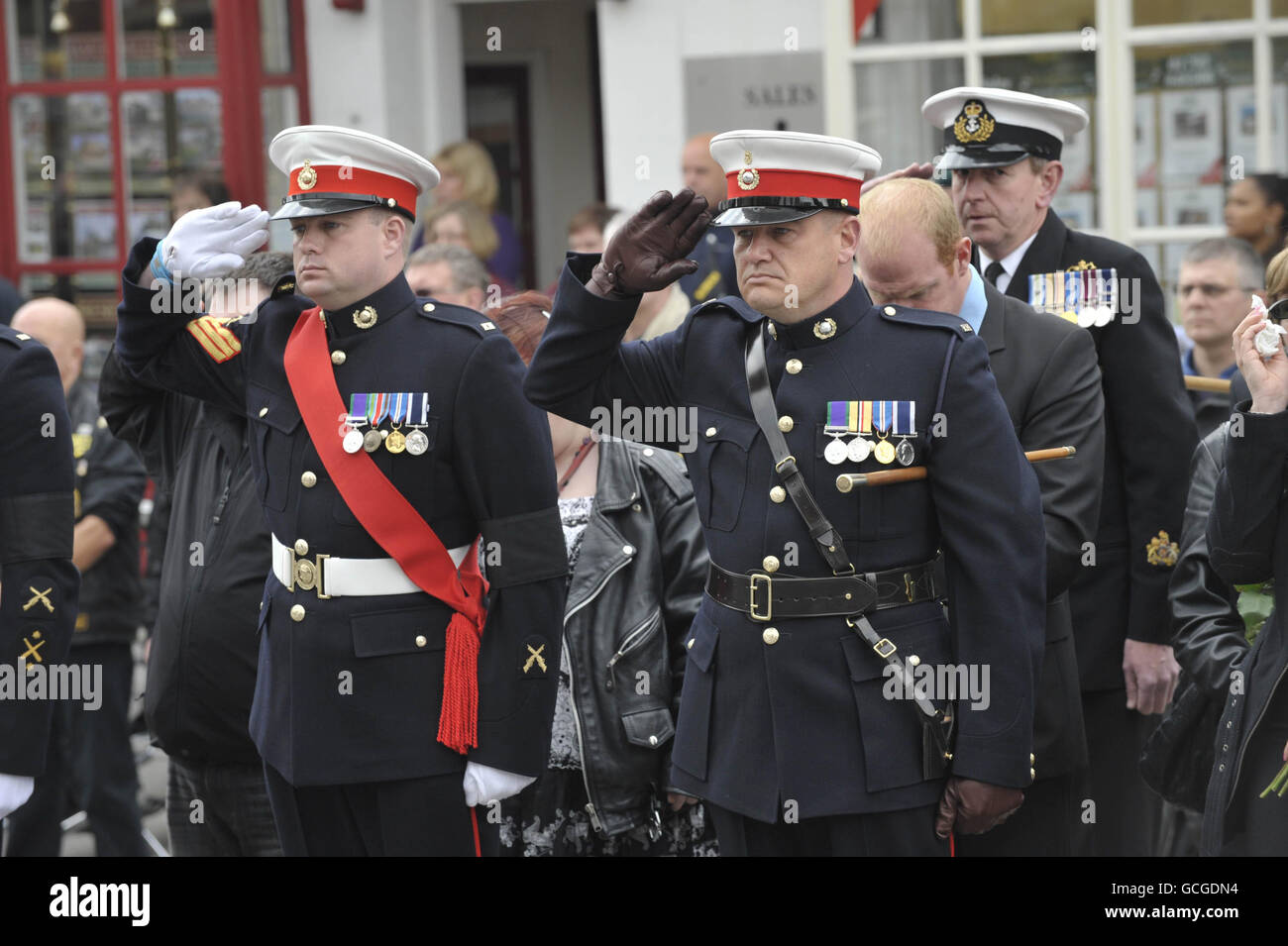 I Royal Marines salutano come il cuore che porta la bara del caporale britannico Christopher Harrison del 40 Commando, Royal Marines, passa attraverso la High Street di Wootton Bassett, Wiltshire. Foto Stock