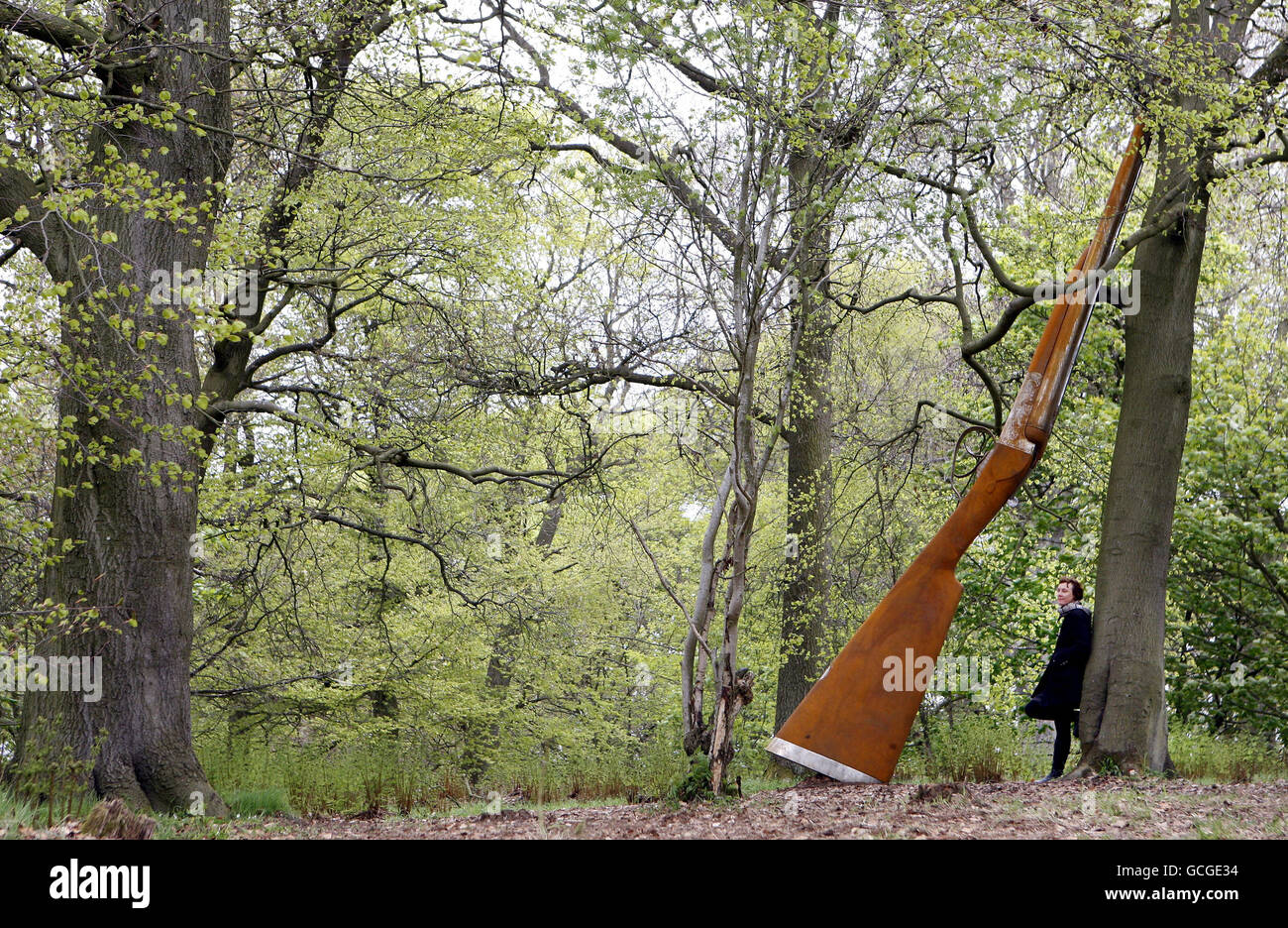 L'artista Cornelia Parker con la sua opera 'Landscape with Gun and Tree' un fucile da caccia in acciaio di 9m che pende contro un faggio, una delle nuove opere ufficialmente svelate oggi a Giove Artland vicino Edimburgo. Foto Stock