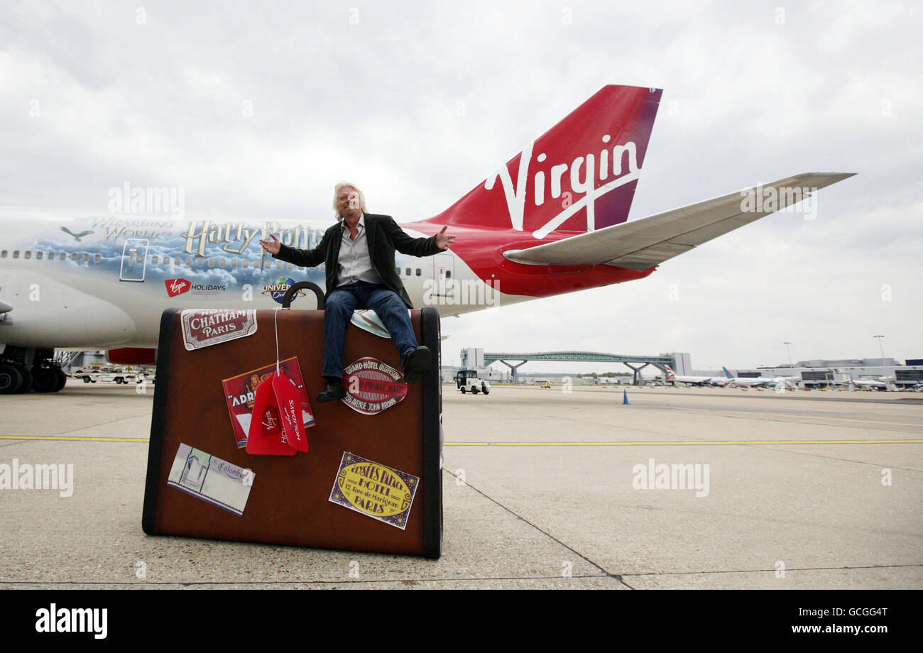 Sir Richard Branson siede su una valigia gigante all'aeroporto di Gatwick,  Sussex di fronte ad un velivolo Virgin liveried di Harry Potter durante una  chiamata fotografica per celebrare il 25° anniversario delle