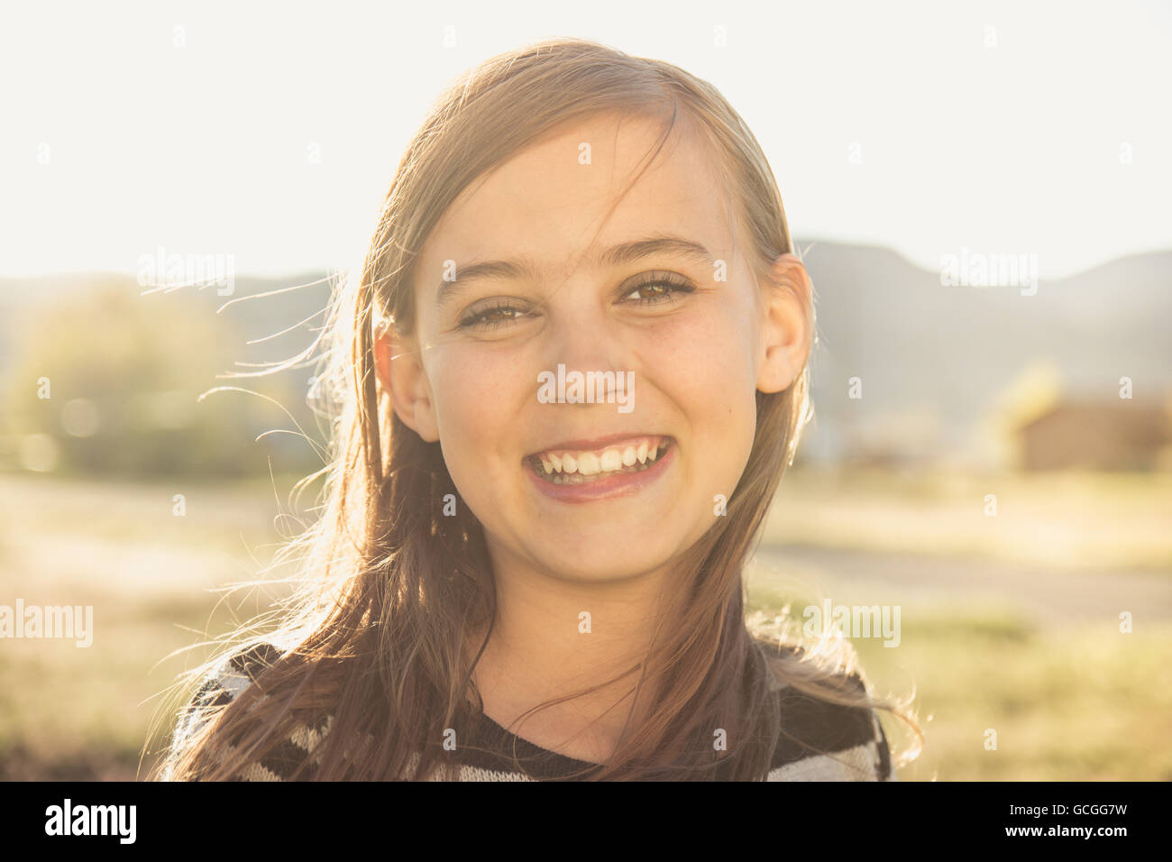 Bella brown-eyed ragazza sorridente in un soleggiato Campo. Foto Stock